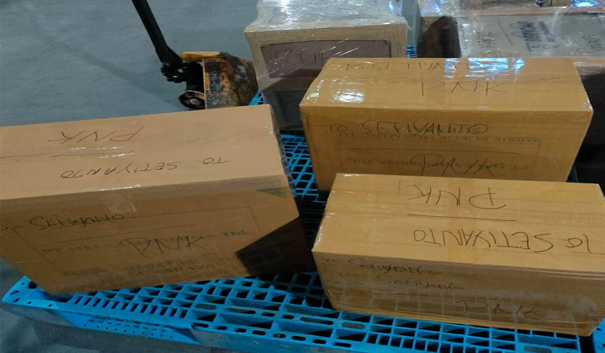 Kardus cokelat berisi barang yang sudah dikemas rapi dengan lakban dan label alamat di atasnya.